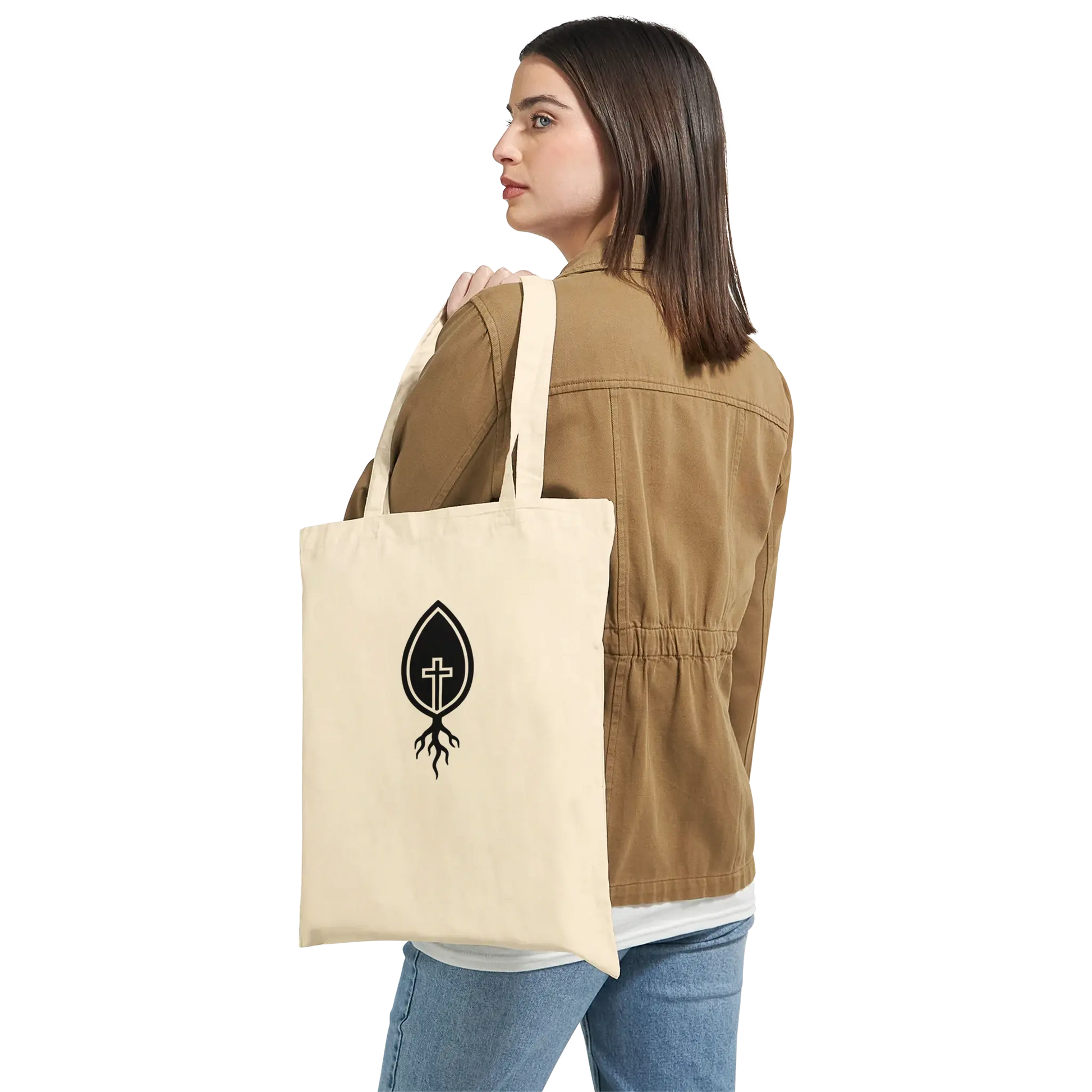 Woman holding natural canvas tote bag with black Christian cross and root logo